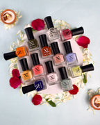 Xprss Nail Polish collection with multiple colorful bottles arranged with flowers and candles